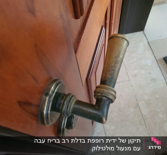 ידית דלת מתכתית על דלת עץ